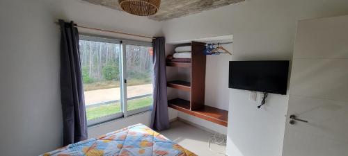 um quarto com uma janela, uma televisão e uma cama em Mar y Laguna em José Ignacio