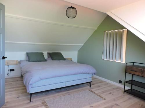 a bedroom with a white bed with green walls at Dijkhuis Driepolders in Biervliet