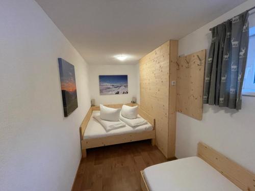 Habitación pequeña con cama y ventana en Ferienwohnung Roschitz, en Schruns