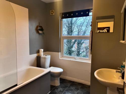 a bathroom with a tub and a toilet and a sink at Yeovil Apartments in Yeovil