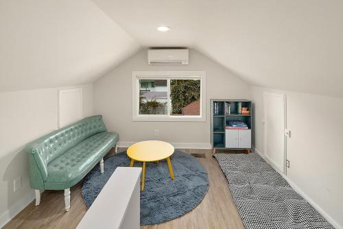 a living room with a green couch and a table at The I5 Cottage BY Betterstay in Seattle