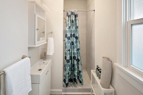 a bathroom with a shower curtain and a sink at The I5 Cottage BY Betterstay in Seattle