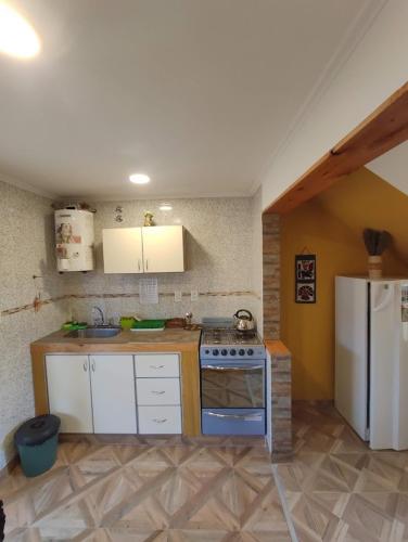 a kitchen with a stove and a refrigerator at CABAÑAS MECHI in Mar del Plata