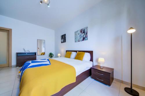 ein Schlafzimmer mit einem Bett mit einer gelben und blauen Decke in der Unterkunft Prime Spot, Stylish Stay in St Julian's, Paceville, APT 8 in St Julian's