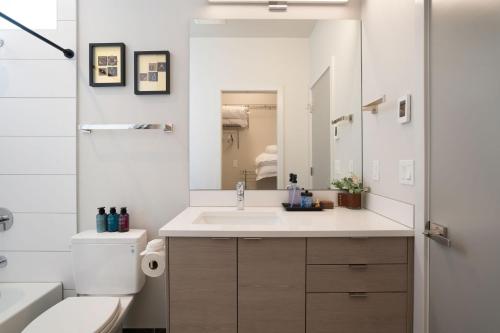 a bathroom with a sink and a toilet and a mirror at Wallingford Place BY Betterstay in Seattle