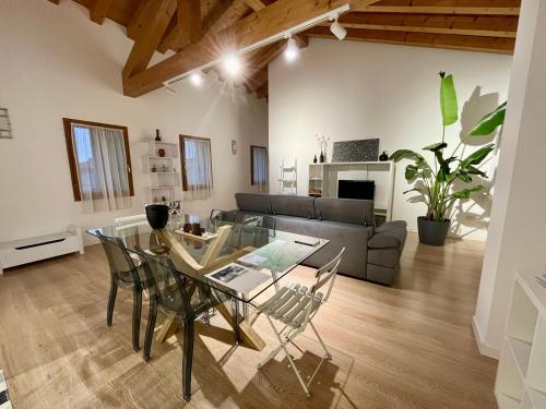 ein Wohnzimmer mit einem Glastisch und Stühlen in der Unterkunft Ca' Mantoet Valdobbiadene in Valdobbiadene