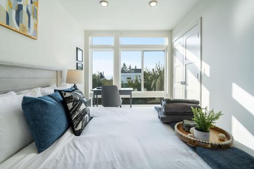 una camera da letto con un grande letto bianco con una pianta di Wallingford View Suite BY Betterstay a Seattle