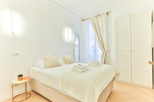 une chambre blanche avec un lit et une fenêtre dans l'établissement Charming 2BR - 6P - Eiffel Tower, à Paris