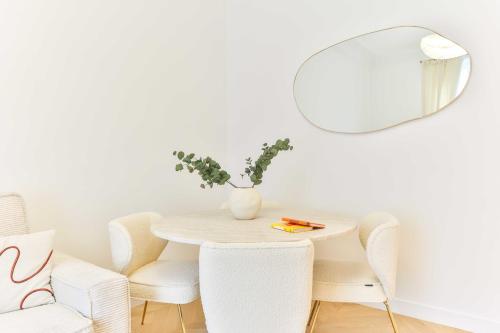 - une table à manger blanche avec des chaises et un miroir dans l'établissement Charming 2BR - 6P - Eiffel Tower, à Paris