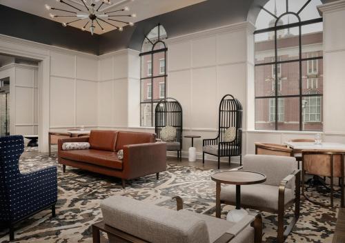 a living room with chairs and a couch and tables at Hotel Indigo Baltimore Downtown by IHG in Baltimore