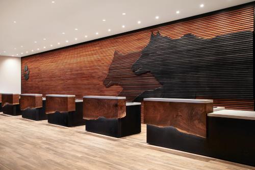 un hall avec une rangée de tables et un grand mur dans l'établissement Great Wolf Lodge Manteca, à Manteca