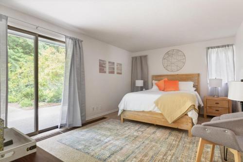 a bedroom with a bed and a large window at Whidbey Gathering Place BY Betterstay in Coupeville