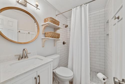 ein Badezimmer mit Toilette, Waschbecken und Spiegel in der Unterkunft Bon Vie in Gulf Shores