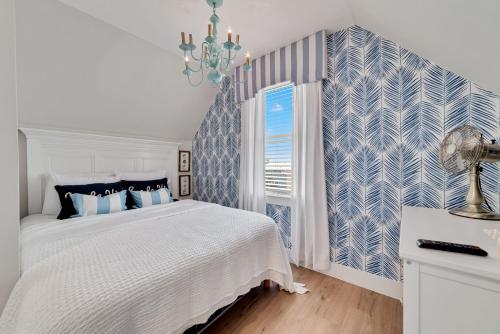 ein weißes Schlafzimmer mit einer blau und weiß gemusterten Wand in der Unterkunft Bon Vie in Gulf Shores
