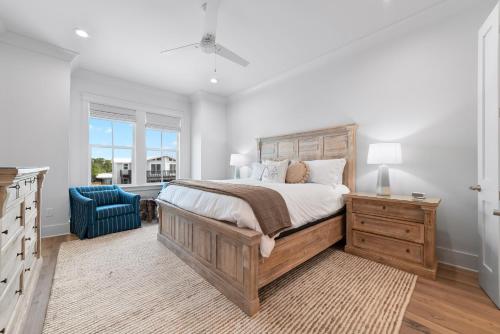- une chambre avec un grand lit et une chaise bleue dans l'établissement Brown By The Beach, à Orange Beach