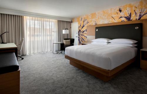 a hotel room with a large bed and a desk at Westchester Marriott in Tarrytown