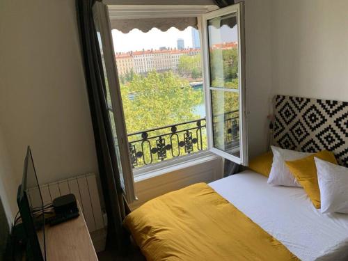 - une chambre avec un lit et une grande fenêtre dans l'établissement Chez Alam à L'opéra de Lyon, à Lyon