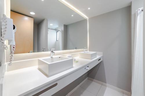 baño con 2 lavabos y espejo grande en City Express Suites by Marriott Anzures en Ciudad de México
