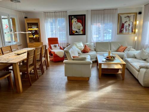 a living room with a couch and a table at Engel Ingold Lodge Chalet "Bärgblümli" in Habkern