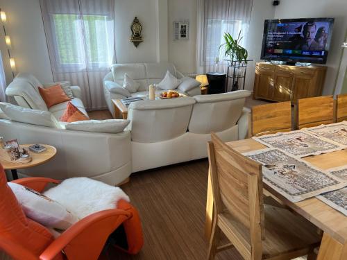 uma sala de estar com mobiliário branco e uma televisão em Engel Ingold Lodge Chalet "Bärgblümli" em Habkern
