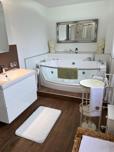 a bathroom with a tub and a sink and a mirror at Engel Ingold Lodge Chalet "Bärgblümli" in Habkern