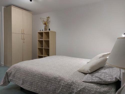 una camera bianca con letto e armadio di Casa Vacanze Aenaria-Ristrutturato 2024 a Ischia