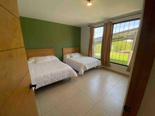 a bedroom with two beds and a large window at Villa privada con una vista espectacular! in Aguascalientes