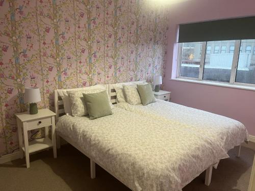 a bedroom with a bed with a flowery wallpaper at Duplex Flat Bedworth Town Centre in Bedworth