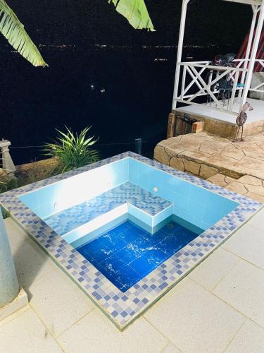 a swimming pool with blue tiles on the ground at Hermosa cabaña privada cerca a Tulua con jacuzzi in La Carmine