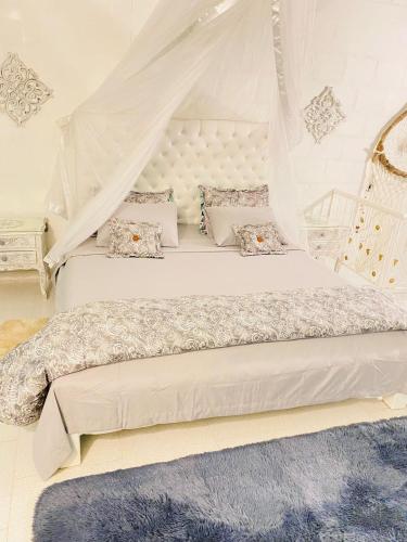 a bedroom with a white bed with a canopy at Hermosa cabaña privada cerca a Tulua con jacuzzi in La Carmine