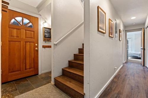 a hallway with stairs and a wooden door at Trailblazer Chalet at Olympic Valley with Private Hot Tub and Ski Shuttle in Alpine Meadows