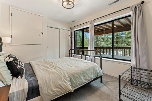 a bedroom with a bed and a large window at Trailblazer Chalet at Olympic Valley with Private Hot Tub and Ski Shuttle in Alpine Meadows