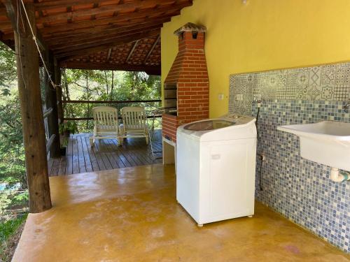 ein Badezimmer mit einem Mülleimer und einem Waschbecken auf einer Terrasse in der Unterkunft Chácara das Araucárias in São Francisco Xavier
