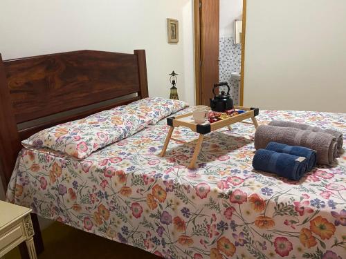 ein Schlafzimmer mit einem Bett und einem Tisch darauf in der Unterkunft Chácara das Araucárias in São Francisco Xavier