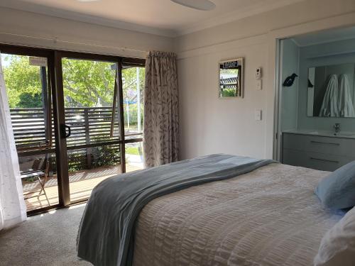 a bedroom with a bed and a sliding glass door at Kerikeri Central House in Kerikeri