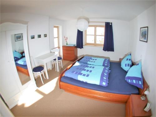 a bedroom with a bed and a table and a desk at Ferienwohnung Am Wundergraben inkl. Chiemgaukarte in Ruhpolding