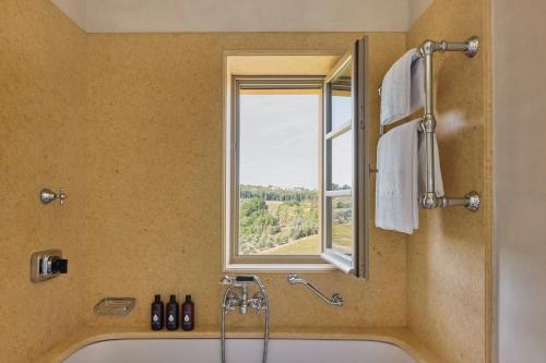 a bathroom with a bath tub and a window at Castello Del Nero - Podere San Filippo in Tavarnelle in Val di Pesa