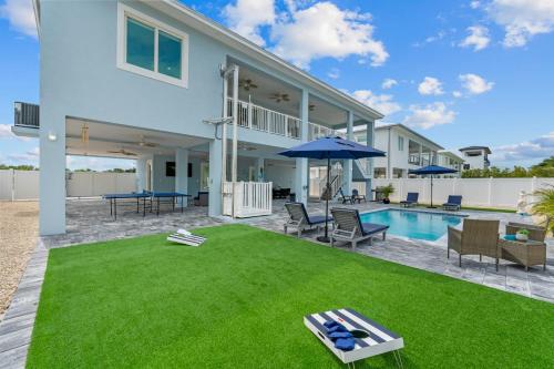 a house with a lawn and a pool at Mermaid's Paradise ~ Pool ~ Dock ~ Games ~ Views in Marathon