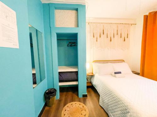 a bedroom with a bed and a blue wall at ITH San Diego Mission Beach Backpacker Hostel in San Diego