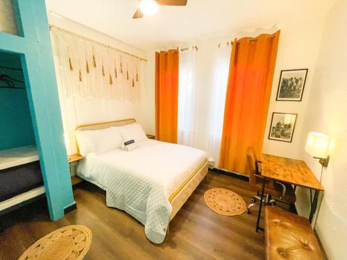 um quarto com uma cama e cortinas cor de laranja em ITH Mission Beach Backpacker Hostel em San Diego