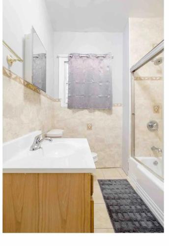 a white bathroom with a sink and a shower at SUITE DREAMs CARROLL 10 in Paterson