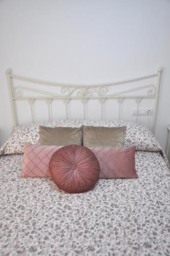 a bed with four pillows and a white headboard at Apartamento Jilguero con parking individual privado in Sanlúcar de Barrameda