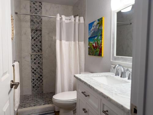 a bathroom with a toilet and a sink and a shower at Kihei Bay Surf 130- Garden View Studio, FREE PARKING in Kihei