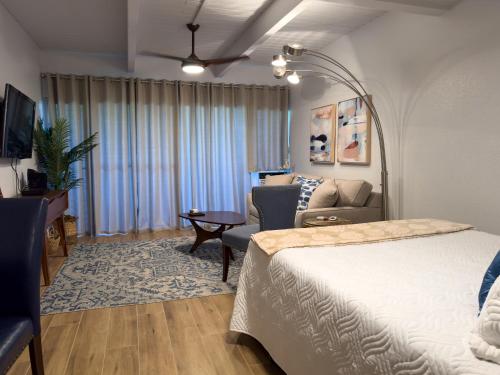 a bedroom with a bed and a couch and a table at Kihei Bay Surf 130- Garden View Studio, FREE PARKING in Kihei