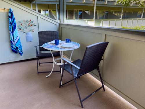 a small table and chairs on a balcony at Kihei Bay Surf 130- Garden View Studio, FREE PARKING in Kihei