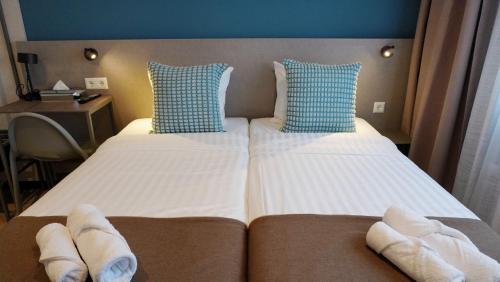 a hotel room with a bed with towels on it at Hotel Fogo Amsterdam in Amsterdam