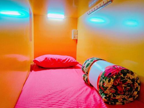 a small bedroom with a bed with pink sheets at Star Capsule Hostel Near Burjuman Metro Station in Dubai