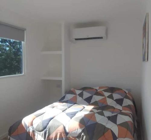 a bedroom with a bed and a window at Los tordos posada in Puerto Madryn