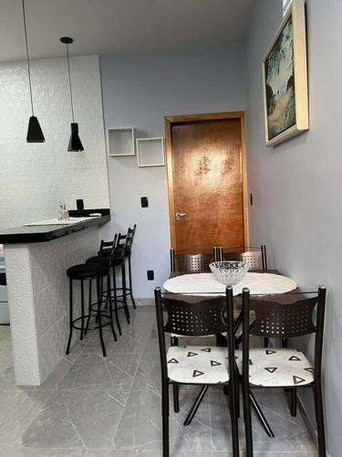 a kitchen with a table and chairs and a counter at Kitnet Cidade de Goiás - Go in Goiás