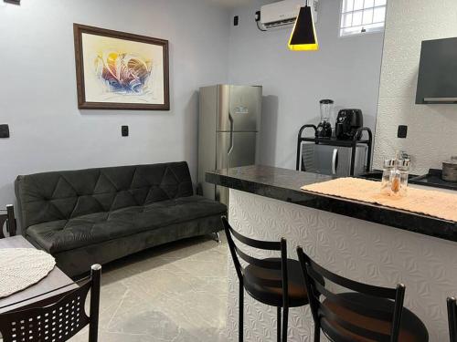 - une cuisine avec un bar et un canapé dans la chambre dans l'établissement Kitnet Cidade de Goiás - Go #02, à Goiás